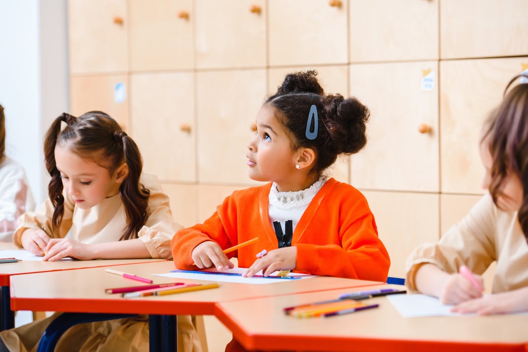 Child Looking Up Sitting Next to Classmates